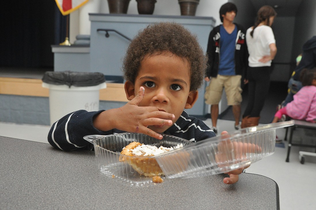 Anthony Glover, 2, sneaks a taste of pumpkin pie at the Buddy Taylor site.