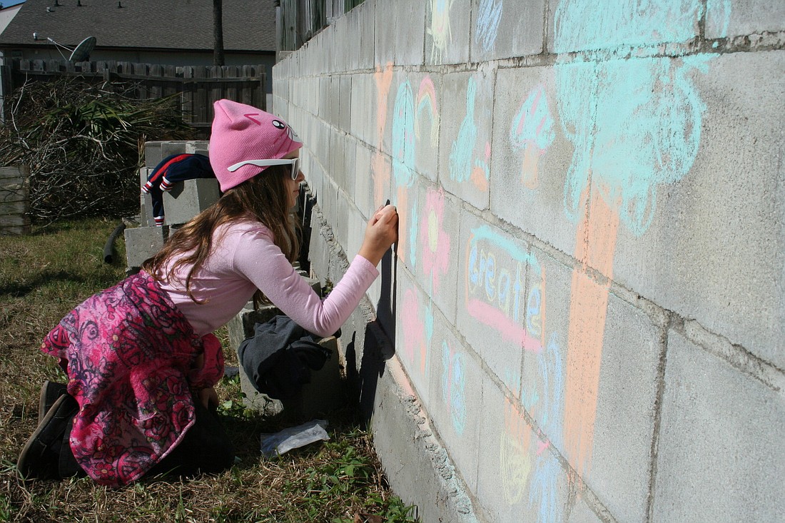 Jade Hillman, 9, works on a chalk mural on one of the gardenÃ¢â‚¬â„¢s walls.