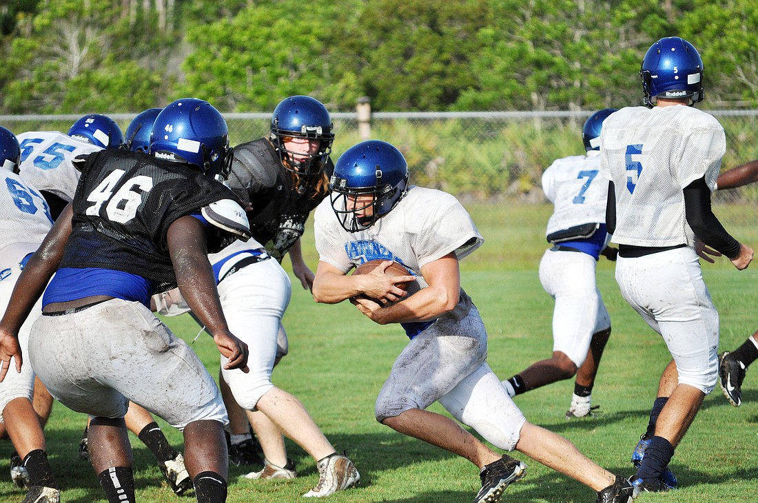 Brandon Fagen carries the ball against the Pirates defensive. Full pads were worn; some hard hits were dished out.