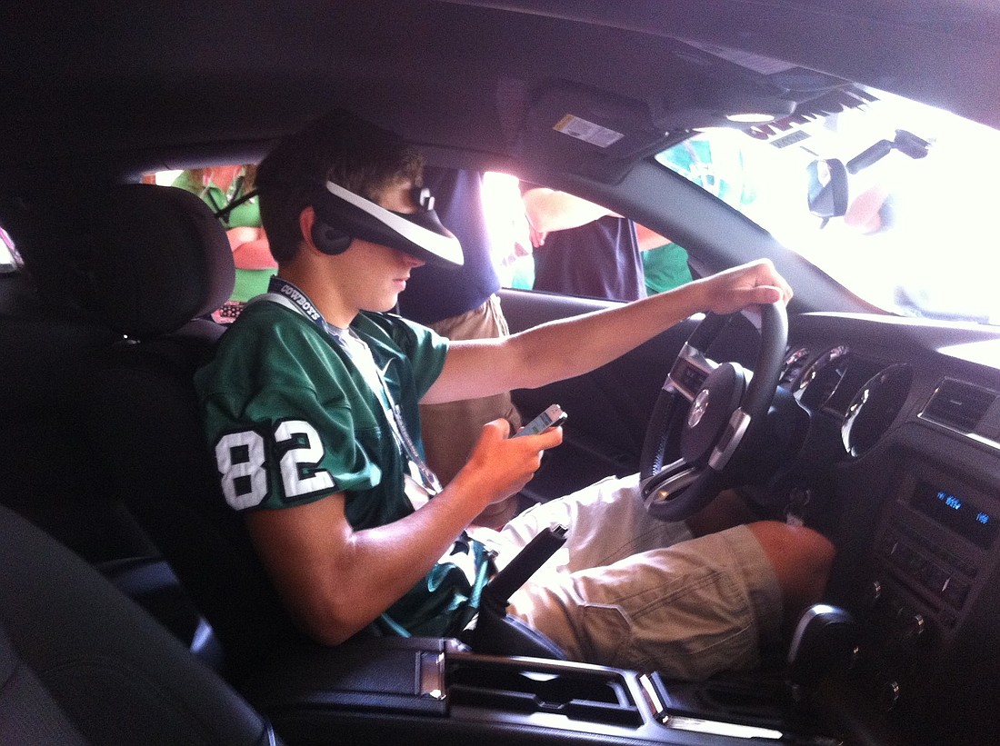 Charlie Picano attempts to answer a text while in the driving simulator.