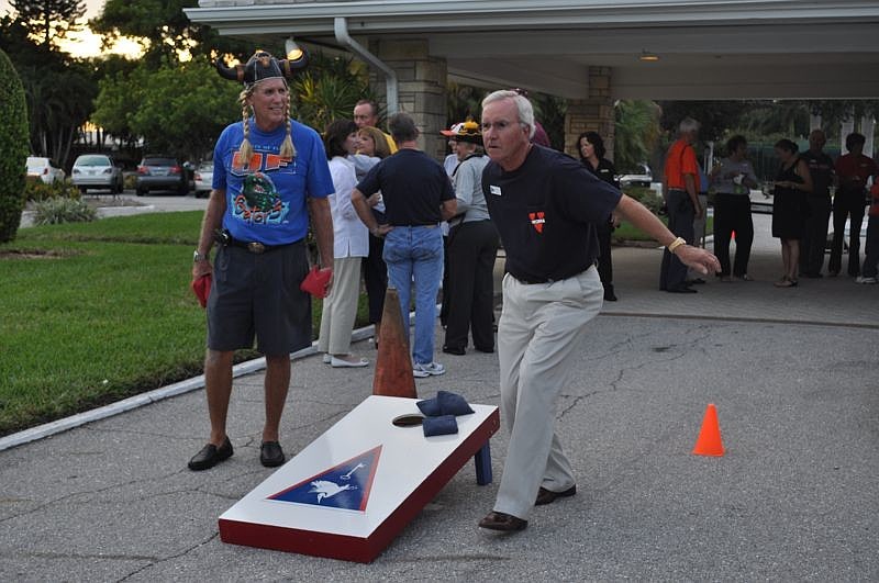 John Tendall watches as David Taylor tosses a beanbag during a round of cornhole.