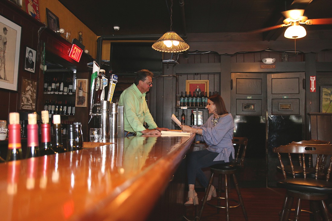 Doug and Lillian Rand go over paperwork at the bar of Billy's Tap Room and Grill. Photo by Jarleene Almenas