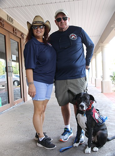 Local Paws of War director Lauren Driscoll, retired Volusia County Firefighter Kevin Rawlins and Dalton. Photo by Jarleene Almenas