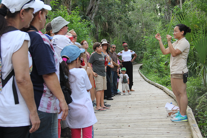 Volunteer Hanh Nguyen leads people on a guided walk through Central Park in July 2017, identifying plants along the way. File photo by Jacque Estes