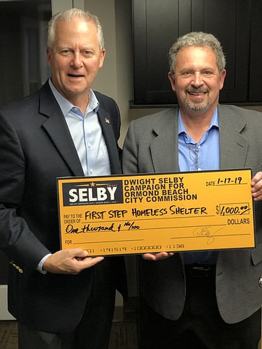 City Commissioner and First Step Board Member Dwight Selby presents a check to First Step Shelter Executive Director Mark Geallis. Courtesy photo