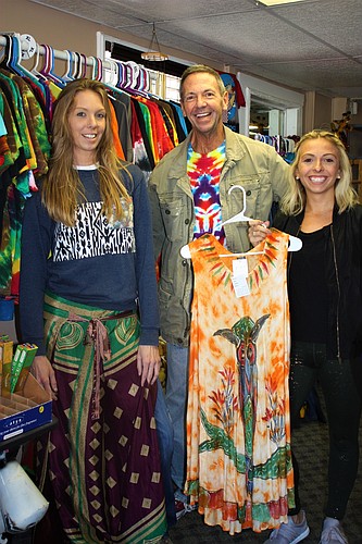 Lindsay Bish and Celiena Hart check out the merchandise at Woodstock South with the help of store owner David Oshman. Bish is wearing a wrap from the store. Photo by Wayne Grant
