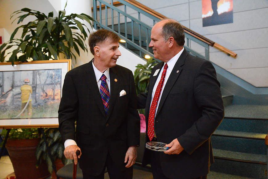 Former Ormond Beach Mayor David Hood shares a moment with Mayor Bill Partington before receiving an award for his efforts and leadership during the wildfires of 1998. File photo by Paige Wilson