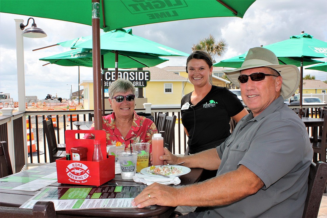 Keith and Grace Rogers, of Flagler Beach, dine at Oceanside Beach Bar and Grill on State Road A1A. Also shown is Kimberly Worley, waitress. Photo by Wayne Grant