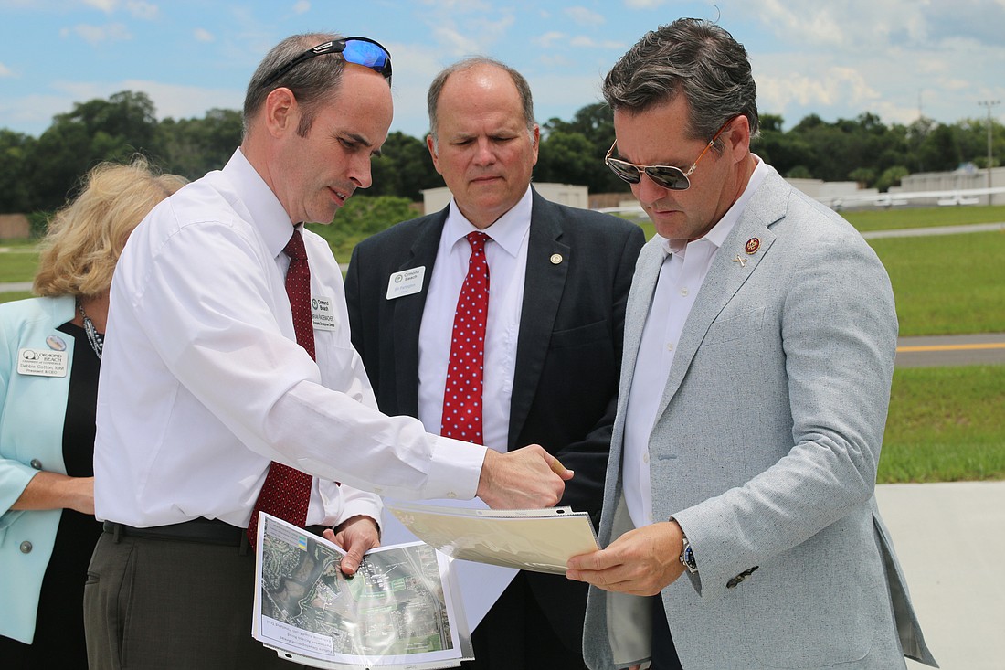 City Economic Development Director Brian Rademacher outlines the areas they will be seeing from the helicopter to Mayor Bill Partington and Congressman Michael Waltz. Photo by Jarleene Almenas