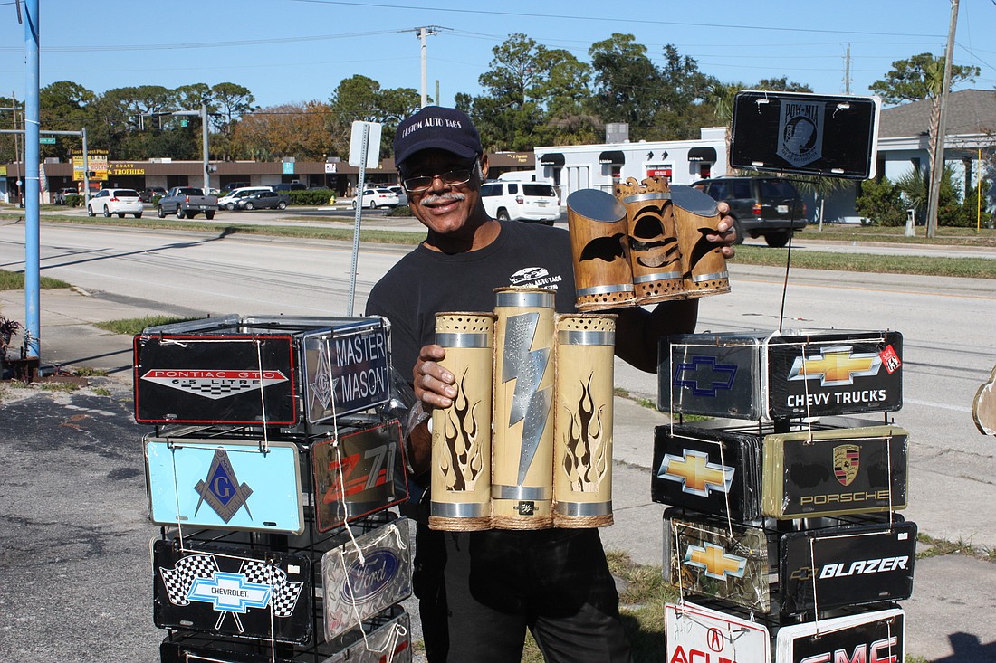 Willie Jackson shows off two of his bamboo creations and his custom tags in front of his business. Photo by Wayne Grant