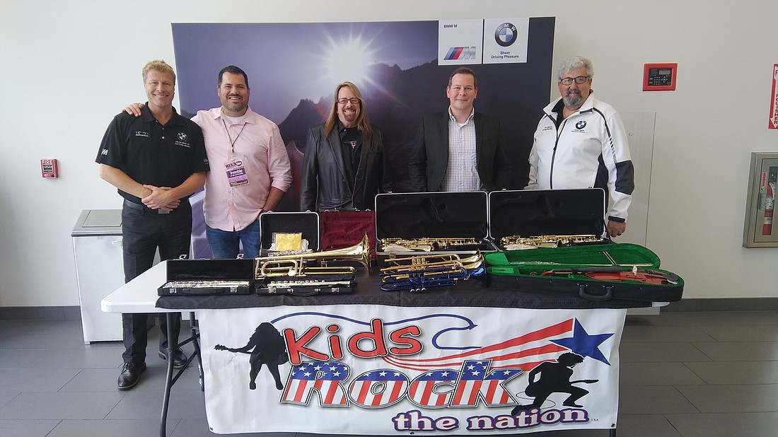 The instruments above will go to students in need. Shown are Robert Dunn, of Fields BMW; John Tremble, of 103.3 the Vibe; Anthony Wild, of Kids Rock the Nation; John Dupuis, of Volusia County Schools; and Lee Grasso, of Fields BMW.