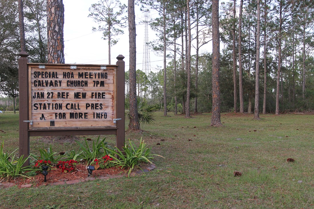 The marquee sign at the entrance of the Plantation Pines neighborhood still shows the meeting date for the fire station proposal. Photo by Jarleene Almenas