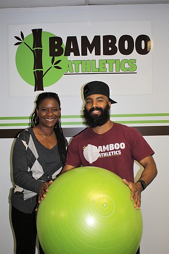 Jennifer Dash, a client at Bamboo Athletics, and owner Jesse Demers hold an exercise ball. Photo by Wayne Grant