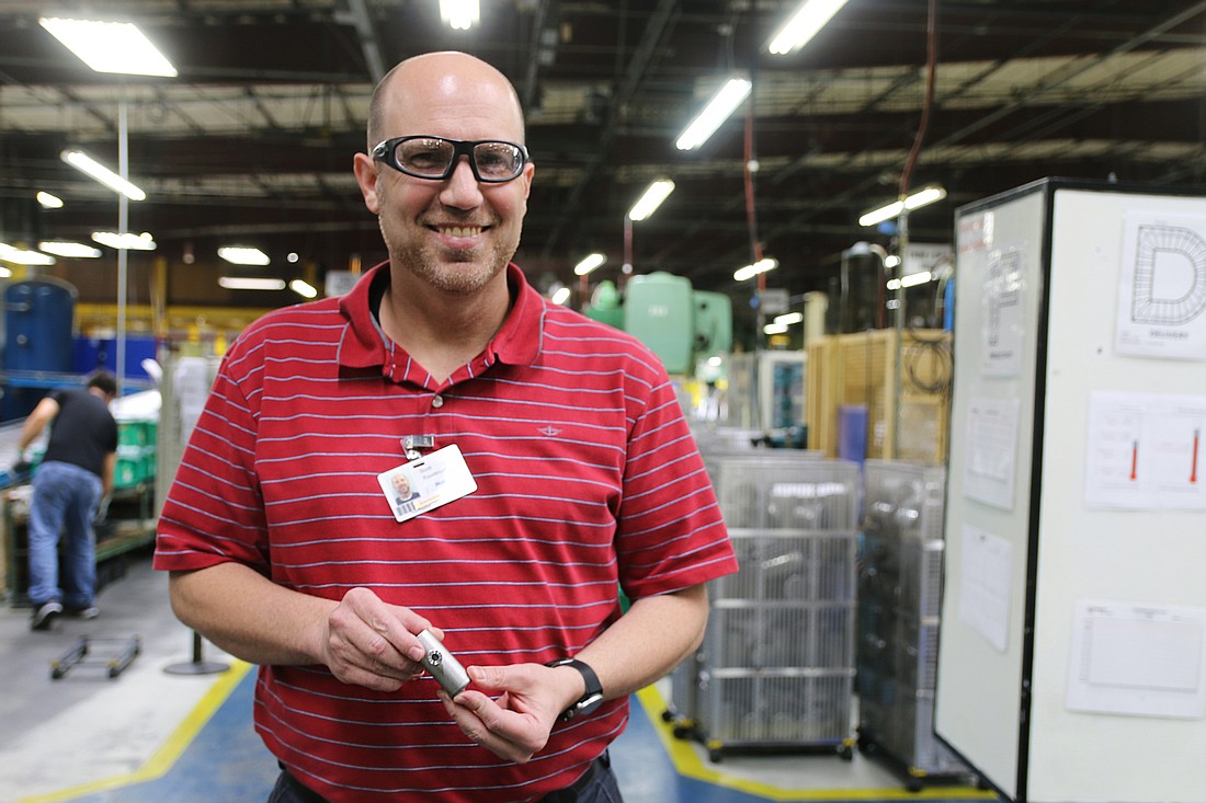 Scott Roudebush, Vice President of Operations at Hudson Technologies, holds the cylindrical part the company manufactures for a Colorado-based customer making virus detection machines. Photo by Jarleene Almenas