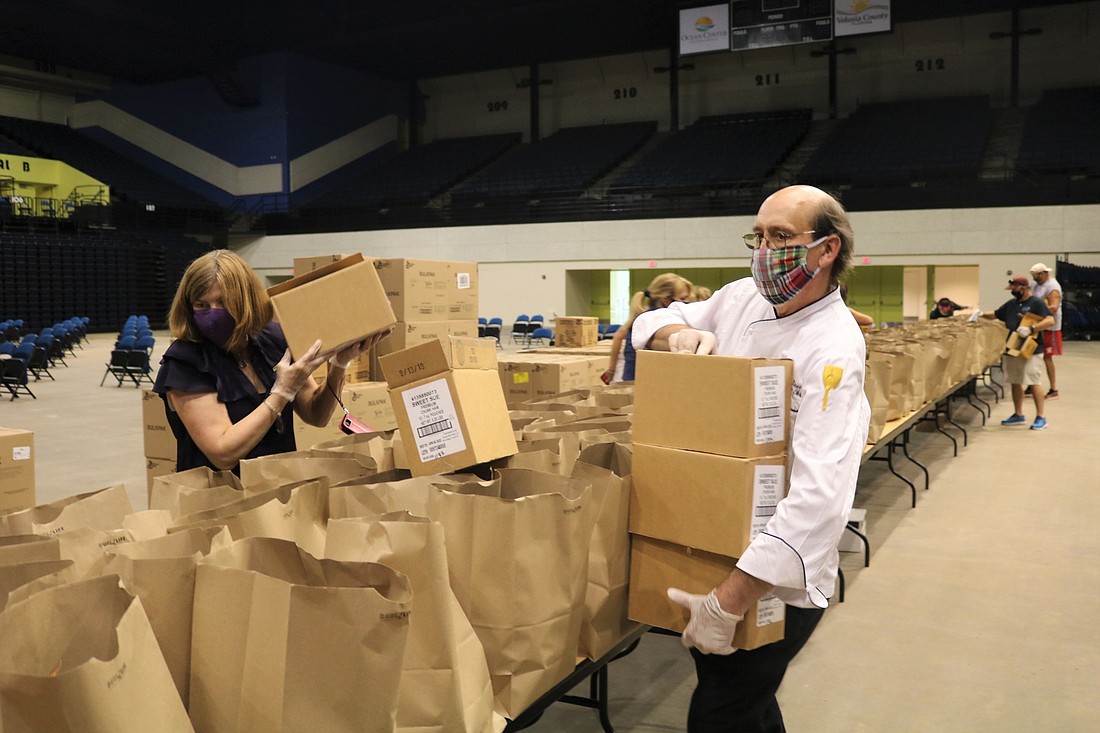 Hilton Daytona Beach Executive Chef Greg Bauer and Maryclaire Pendergast, director of catering and convention services, help pack groceries. Courtesy photo