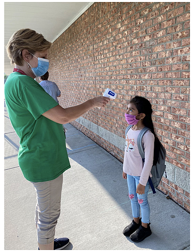 A faculty member at Spirit Elementary takes a student's temperature, which will be a daily occurrence once schools open on Aug. 31. Courtesy photo
