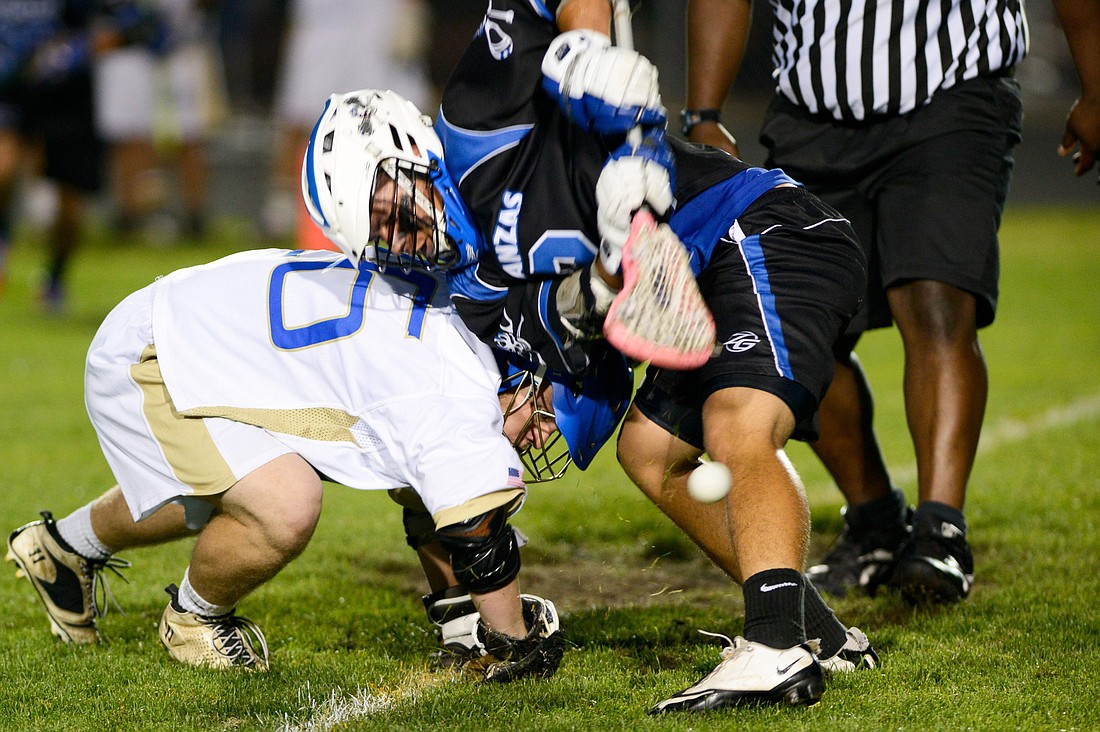 Pablo Torres (right) fights for the ball during a faceoff in Wednesday night's District 6 boys lacrosse semifinal. PHOTO BY BOB ROLLINS/COYOTE PHOTOGRAPHY