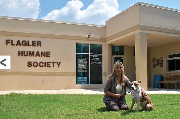 Flagler Humane Society Director Amy Wade-Carotenuto with a shelter dog in front of the Humane Society building. Courtesy photo.