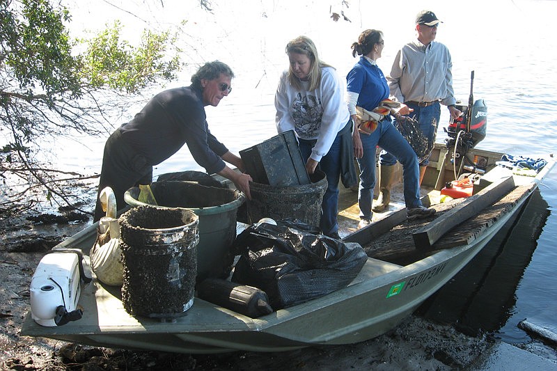 Lynn Longenecker, left, Denise Kleiner, Lori Dengler and Bill Growney return to the ramp with a boat load of items recovered from the river.