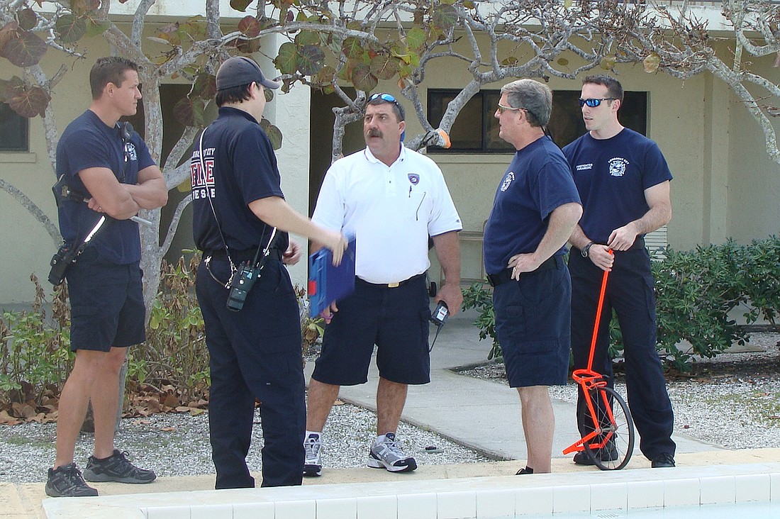 Dep. Chief Skip Falcone, center, discusses building conditions with firefighter/paramedics.