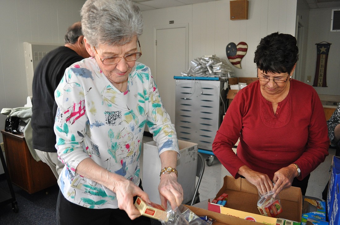 Lodge members Mary Bilkie and Joanne DiCarlo packaged raisins, jerky and other treats to put in backpacks for children in need at Freedom Elementary School.