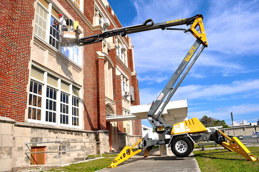 Chris Innocenti lays vinyl over the windows at the Sarasota Museum of Art for future enhancements to the faÃ§ade.
