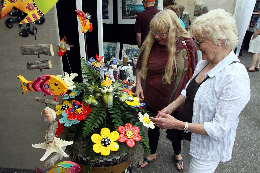 Nancy Koci and Esther Erickson look at some of the yard art creations by Aart Vark Studios during the 17th annual Siesta Key Craft Festival Saturday, Feb. 5, in Siesta Key Village.