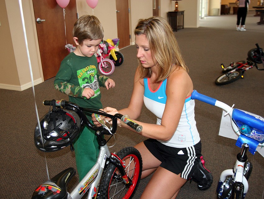 Kelly Polivchak helped her son, Chase, 4, decorate his bike.