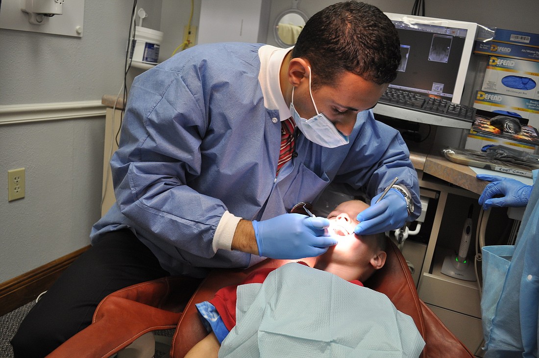 Dr. Amir Guirguis examines the mouth of 6-year-old Eason Rogers, who attends Prine Elementary.