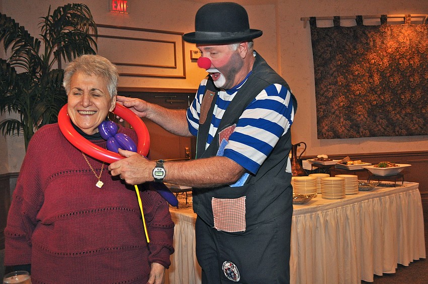 Juggles the Clown (Jeff Lovett) adds some balloon flair to Joanna Tsoukos' wardrobe.