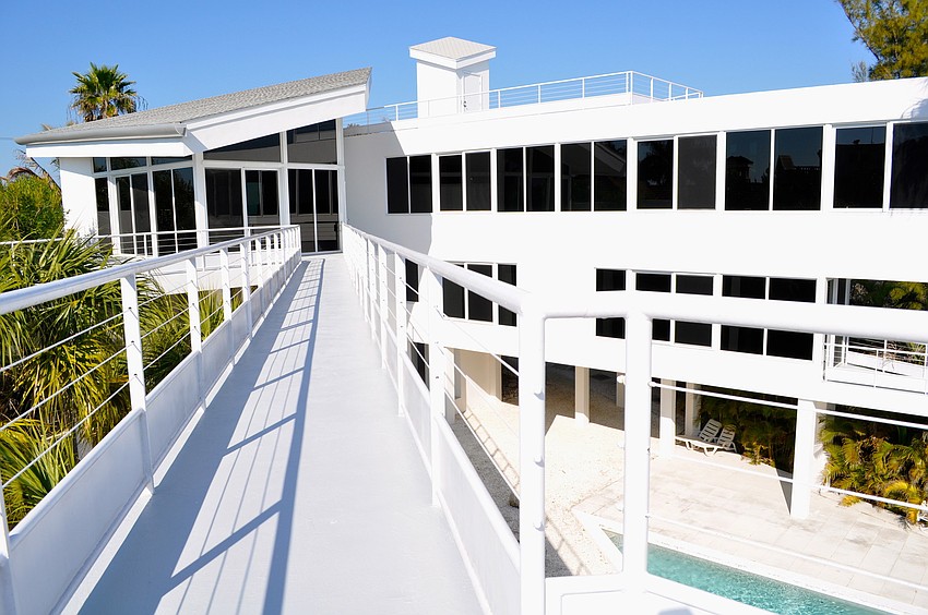 A Modern Sculptural Masterpiece: This dramatic Gulf-to-bay home features a sky bridge and sweeping views from every room and terrace.