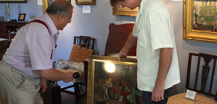Ed Weissman takes a look at a painting brought in by Dane Spencer to be appraised on Sunday, Feb. 20 at the Historical Society of Sarasota County's 2nd Annual Antiques and Appraisals Event, at Phillippi Estate.