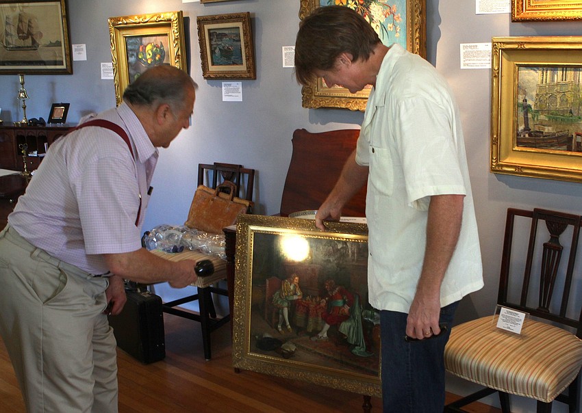 Ed Weissman takes a look at a painting brought in by Dane Spencer to be appraised on Sunday, Feb. 20 at the Historical Society of Sarasota County's 2nd Annual Antiques and Appraisals Event, at Phillippi Estate.
