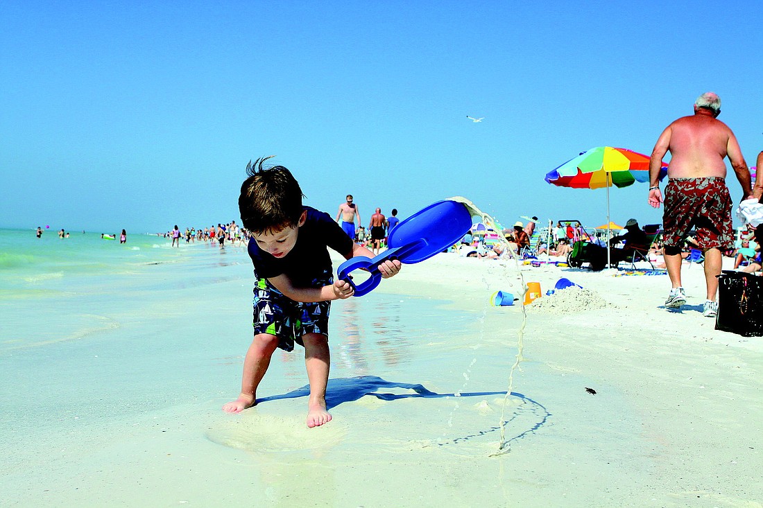 Brenden Bieth, 4, has fun digging in the sand with a big shovel while visiting Siesta Key Beach over Presidents Day weekend.