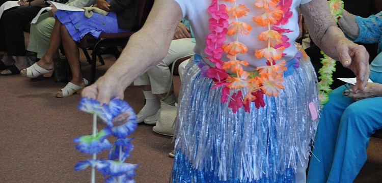 Surprise guest model and Longboat Observer reporter Dora Walters handed out Hawaiian leis as part of her beach-themed ensemble.