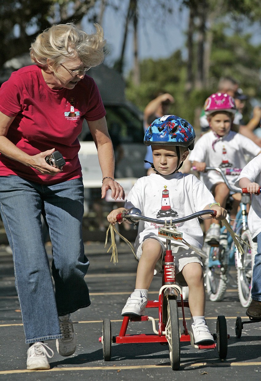 Lighthouse Kids Preschool Director Debbie Woodruff helps Jonah Yacavella, 3, get started.