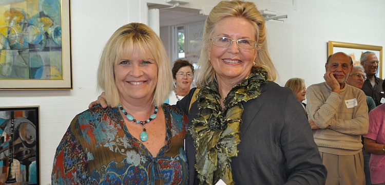 Arts Center director Jane Buckman and Carolyn Cleland who won first prize for her painting, "Homesick."