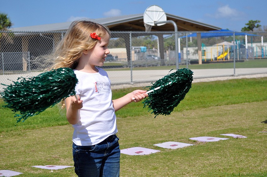 Cameron Seguin cheers on her big sister by waving pom-poms in the air.
