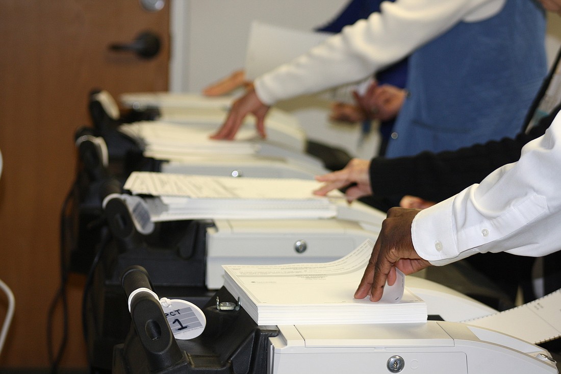 Supervisor of Elections Office employees fed more than 3,400 ballots through scanning machines during the recount.