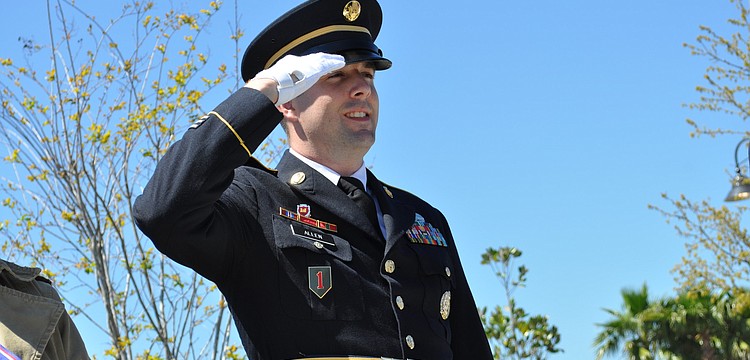 Sgt. Lyle Allen salutes during "The Star Spangled Banner."