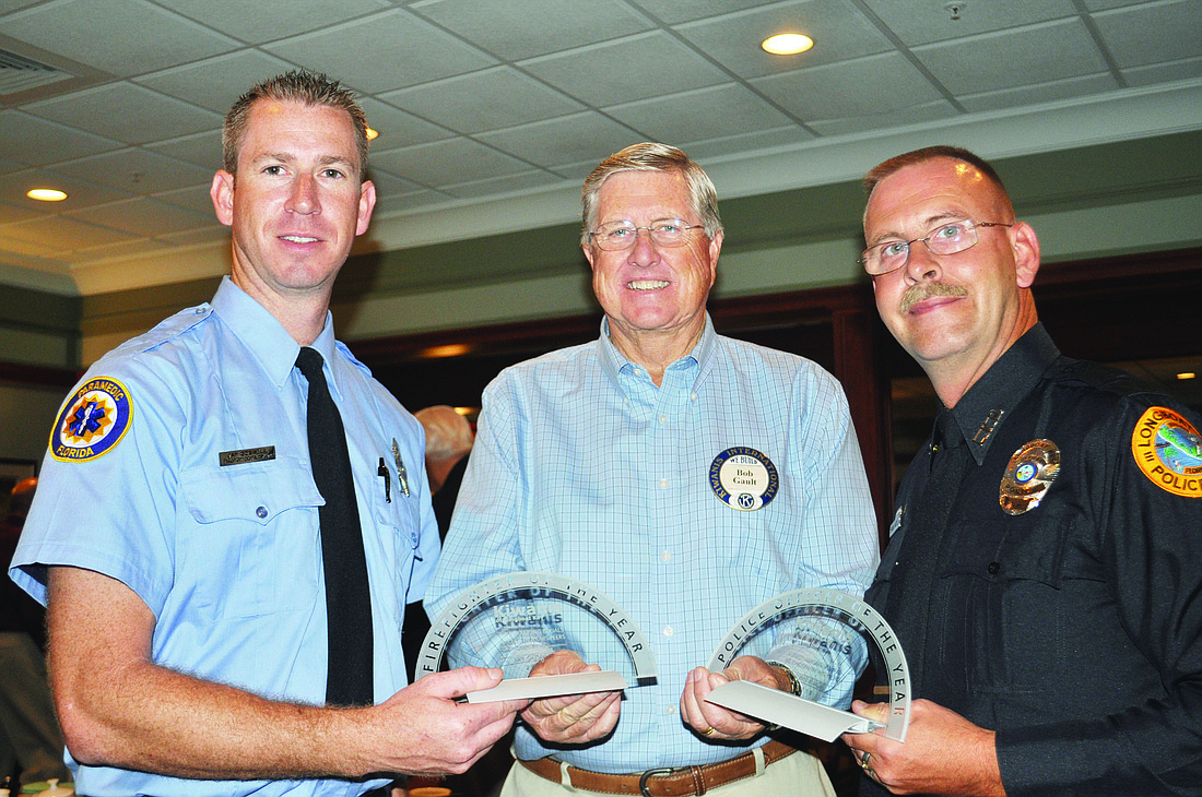 Firefighter/paramedic Jay Gosnell, left, and police officer Shawn Nagell, right, receive their awards from Kiwanis President Bob Gault.