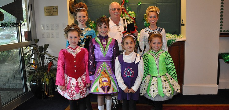 A group of adorable Irish dancers surrounds bagpiper Bill Buckley before he pipes them into the dining room for their St. Patrick's Day performance.