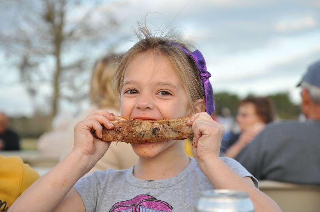 Jillian Peterson, 5, sinks her teeth into a larger-than-life rib at the first Food Truck Tuesday.