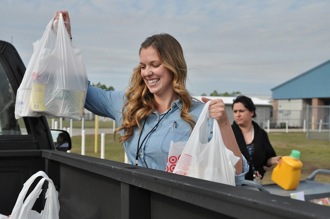 Teacher Anna Bongiovanni loads a truck with groceries at the first food distribution.