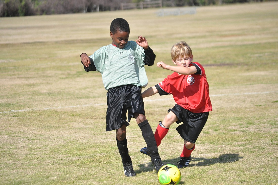 Troy Smith-Wimbush and Chase Magee battle it out on the U8 field.