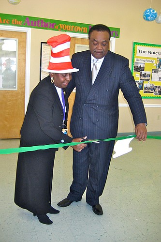 Esther Hamilton, principal, and Gillard Glover, trustee, cut the ribbon that officially opened the library. COURTESY PHOTOS