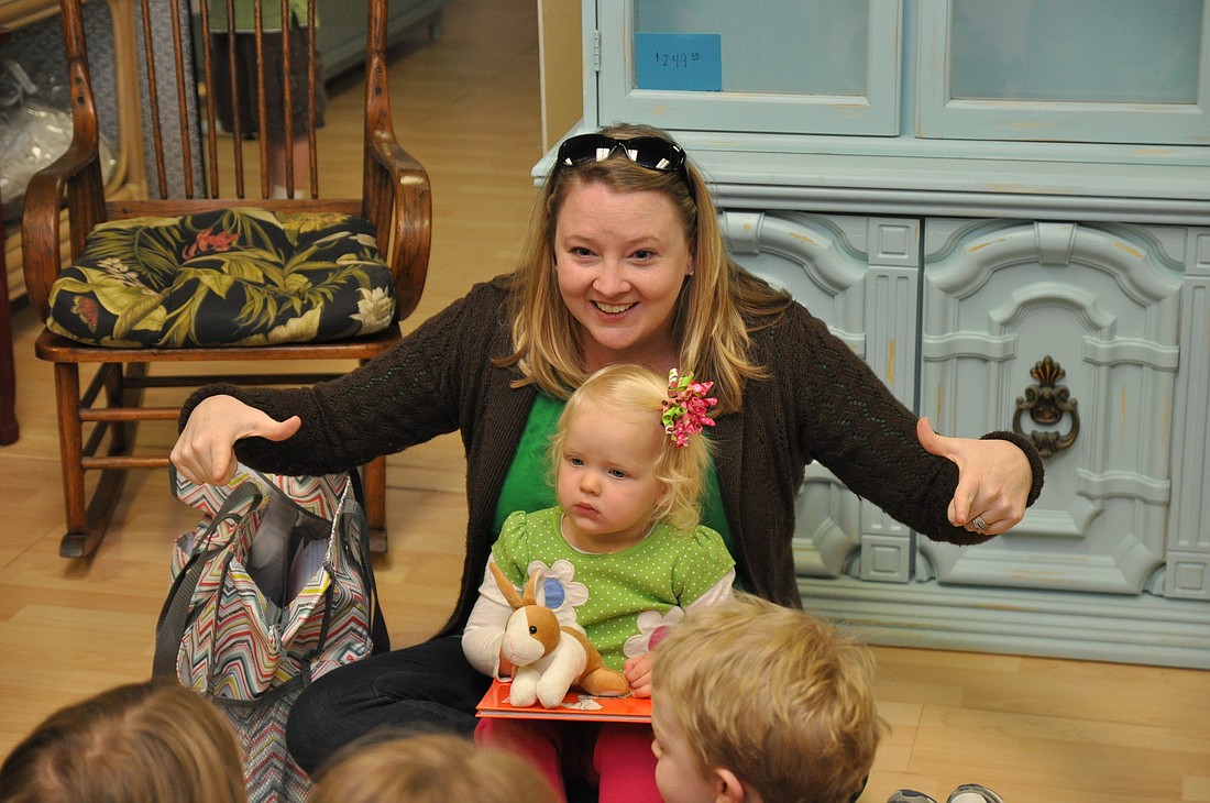 Kelly Zwirn teaches story time participants the sign for house with her daughter, Emma.