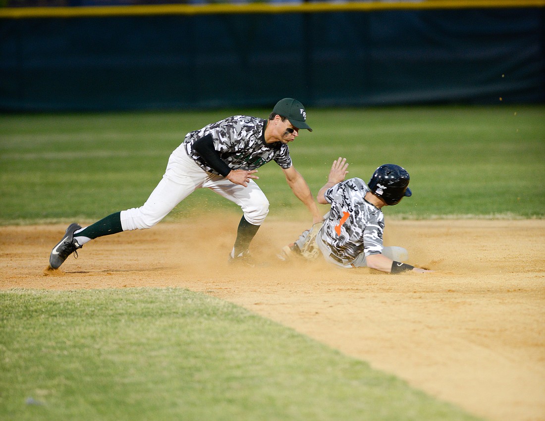 Flagler Palm Coast second baseman Mike Ehman attempts to tag out a Spruce Creek baserunner. PHOTO BY BOB ROLLINS/COYOTE PHOTOGRAPHY