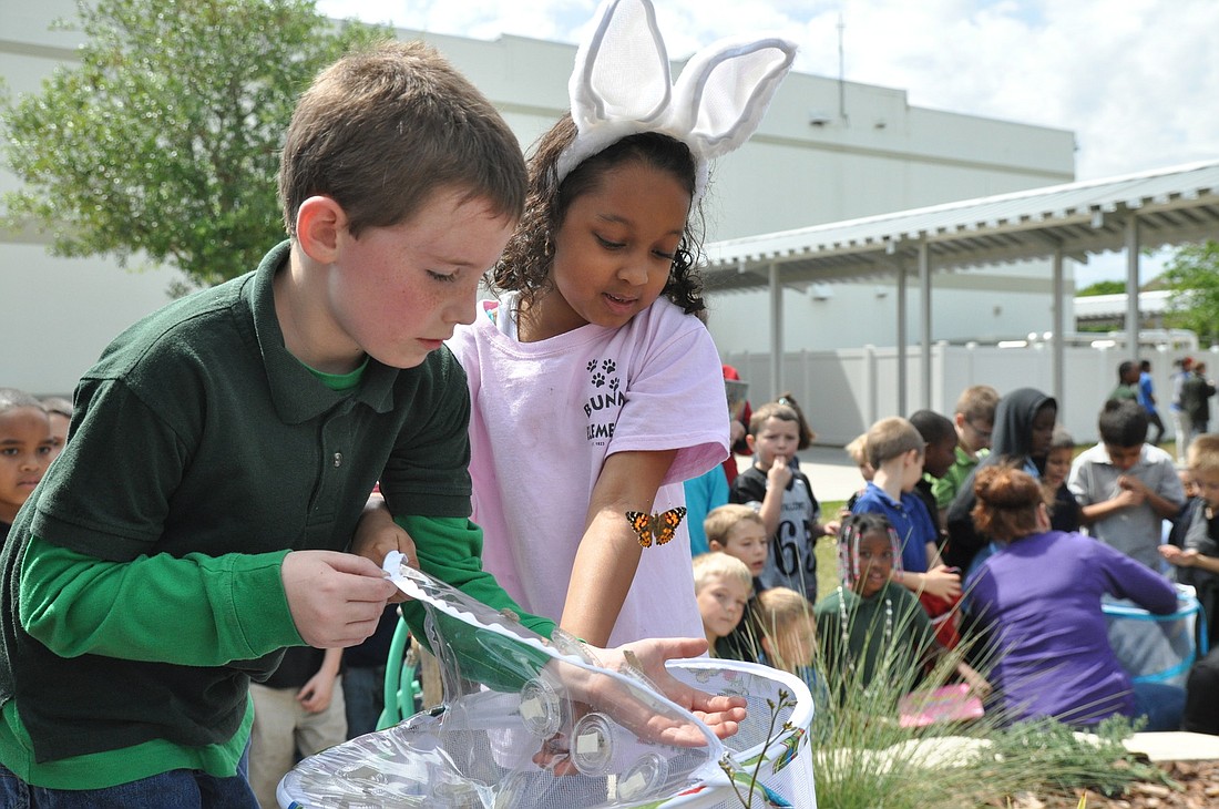 Drew Stage and Anaiya Lalaram release the butterflies that Mary Narin's first-grade students have been observing. SHANNA FORTER