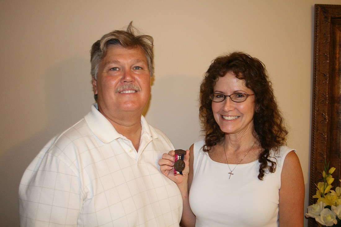 Frank and Nancy Gillotti hold a medal of service issued to Alfred Porter, Frank Gillotti's great-great uncle.